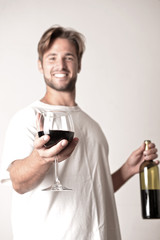 Young man relaxing with a bottle of red win