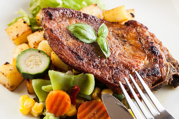 Fried pork with potatoes and vegetables salad