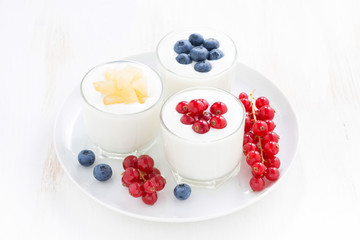 Natural yogurt with fresh berries in glass jars, top view