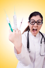 Woman doctor with syringe on white