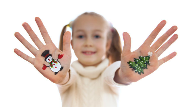 Happy girl demonstrating Christmas symbols painted on her hands.