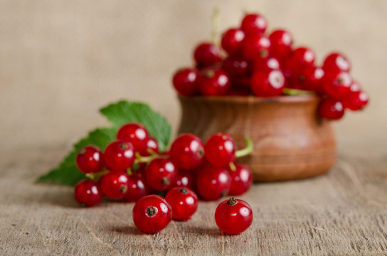 Red currant in wooden plate on the table