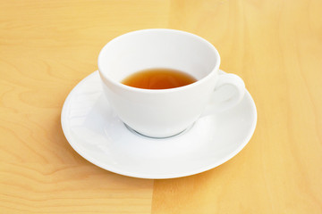 Tea in a white cup on the wood table