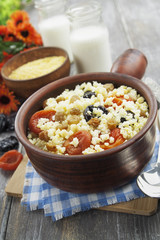 Millet porridge with dried apricots and prunes in a bowl