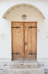 Historical Ornate Wooden Door in a Stone Entry with Arc and Pill
