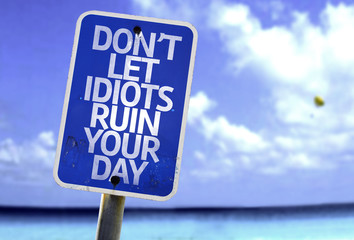 Don't Let Idiots Ruin Your Day sign with a beach on background - obrazy, fototapety, plakaty