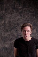 Obraz premium smiling smart guy on a grunge black background