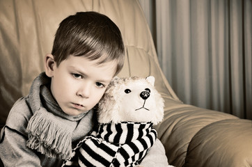 tinted image sad little boy hugging toy dog