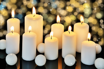 Fototapeta na wymiar nine burning candles on a dark shiny background