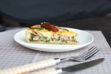 Piece of pie with spinach and fish salmon