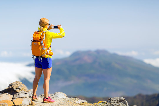 Woman hiker taking photos  in mountains