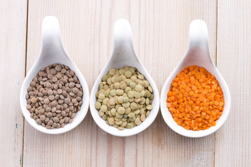 Three kinds of lentil in bowls - red lentil, green lentil and br