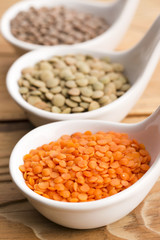 Three kinds of lentil in bowls - red lentil, green lentil and br