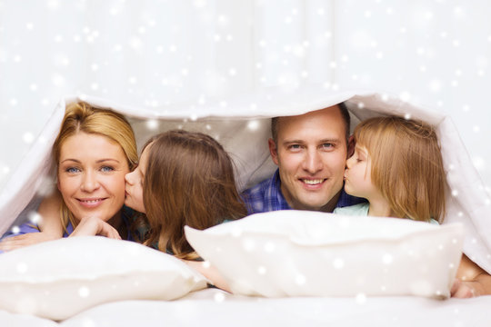 Happy Family With Two Kids Under Blanket At Home