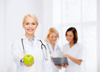 smiling female doctor with green apple