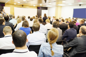The audience listens to the acting in a conference hall