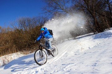 Fototapeta na wymiar Cyclist extreme riding on mountain bike in the snow forest