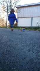 Kind zieht holzspielzeug Eisenbahn Asphalt