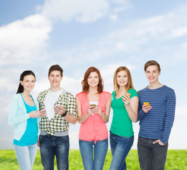 Obraz premium smiling students with smartphones