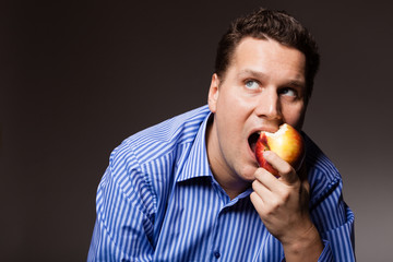 Diet nutrition. Happy man biting apple fruit