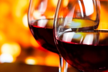 red wine glasses against colorful unfocused lights background