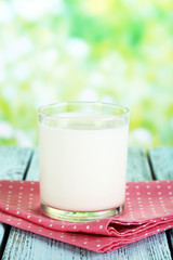 Milk in glass on napkin on natural background