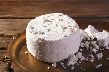 Cottage cheese on metal tray on wooden background