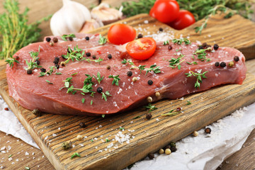 Raw beef steak on wooden table