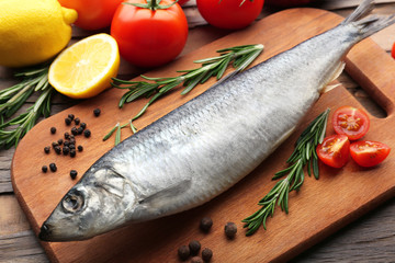 Fresh raw fish and food ingredients on table