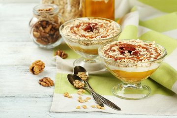 Tasty dessert with oat flakes and honey, on table