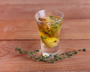 Green olives in oil with spices and rosemary in glass