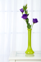 Beautiful bouquet of flowers in vase on window background