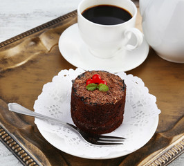 Yummy chocolate cupcake and cup of coffee on tray