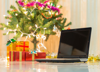 laptop with gift box and christmas lights background