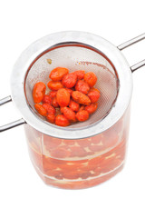strainer and glass with goji berries tincture