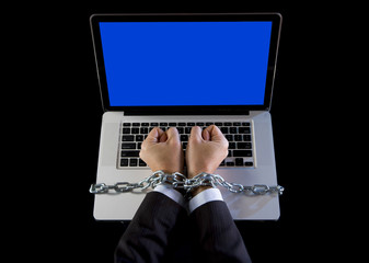 Hands of businessman addicted to work chain to computer