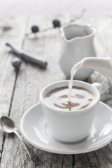 pouring milk from jug cup black coffee