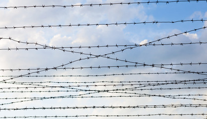 Barbed wire against the cloudy sky background