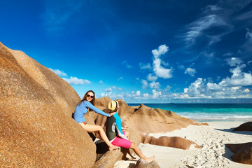 Fototapeta na wymiar Couple at tropical beach wearing rash guard