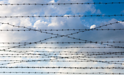 Barbed wire against the cloudy sky background