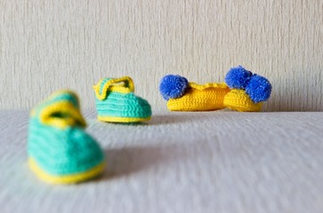 Fototapeta na wymiar Baby booties. Focus on yellow pair