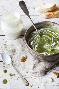 peas and spinach cream soup with sour cream on bowl