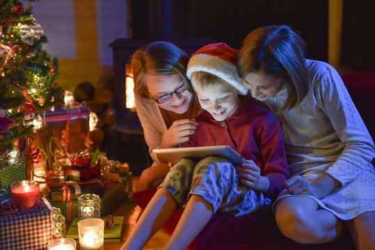 Christmastime, brother and sisters in pajamas having fun on a di