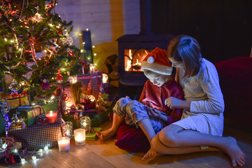 Obraz na płótnie Canvas Christmastime, two kids in pajamas having fun on a digital table