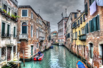 Narrow canal in Venice under a gray sky