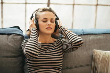 Obraz premium Portrait of young woman listening music in headphones