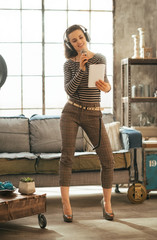 Full length portrait of young woman singing karaoke