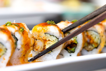 Sushi roll with black chopsticks