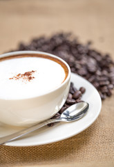 Cappuccino coffee cup and beans
