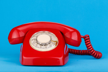 Red telephone on blue background.